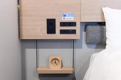 a clock on a shelf next to a bed at Washington R&B Hotel Otsuka Eki Kitaguchi in Tokyo