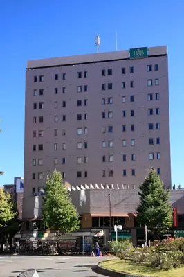 a large building with a street sign on top of it at Washington R&B Hotel Otsuka Eki Kitaguchi in Tokyo