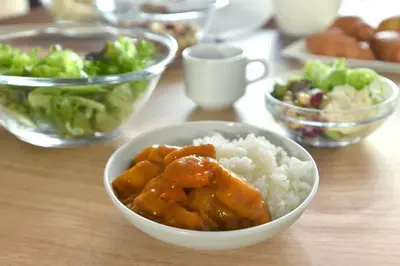 a table with a bowl of rice and a bowl of vegetables at Washington R&B Hotel Otsuka Eki Kitaguchi in Tokyo