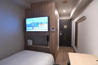 a small room with a bed and a flat screen tv at WASHINGTON R&B Hotel Ueno Hirokoji in Tokyo