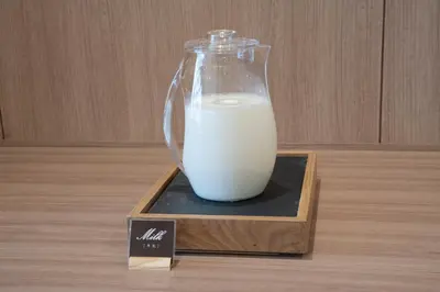 a glass jar of milk sitting on a wooden table at WASHINGTON R&B Hotel Ueno Hirokoji in Tokyo