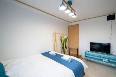 a bedroom with a bed and a flat screen tv at Rea\u65b0\u5c0f\u5ca92\u4e01\u76ee403 in Tokyo
