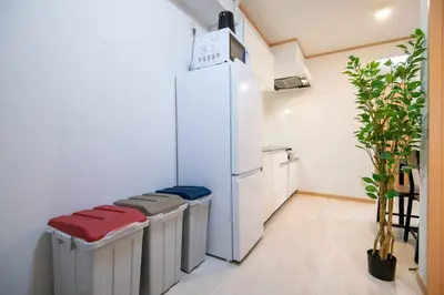 a kitchen with a row of stools and a refrigerator at Rea\u65b0\u5c0f\u5ca92\u4e01\u76ee403 in Tokyo