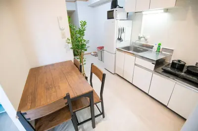 a kitchen with a wooden table and chairs in it at Rea\u65b0\u5c0f\u5ca92\u4e01\u76ee403 in Tokyo