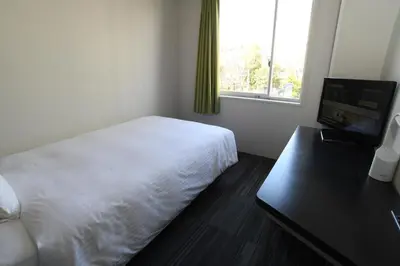 a bedroom with a bed and a desk and a window at Washington R&BHotel TokyoToyocho in Tokyo