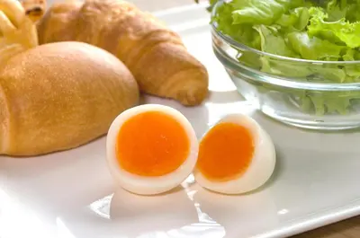 a plate with eggs and lettuce and a bowl of bread at Washington R&BHotel TokyoToyocho in Tokyo