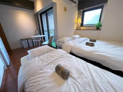 a hotel room with two beds and a window at \u6b4c\u821e\u4f0e\u753a\u306e\u7269\u4ef6 \u6700\u4e0a\u968e \u6771\u65b0\u5bbf\u99c5\u5f92\u6b693\u5206\u65b0\u5bbf\u6e0b\u8c37\u539f\u5bbf\u30a8\u30ea\u30a2 in Tokyo