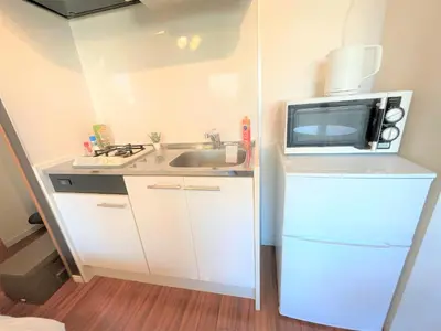 a small kitchen with a sink and a microwave at \u6b4c\u821e\u4f0e\u753a\u306e\u7269\u4ef6 \u6700\u4e0a\u968e \u6771\u65b0\u5bbf\u99c5\u5f92\u6b693\u5206\u65b0\u5bbf\u6e0b\u8c37\u539f\u5bbf\u30a8\u30ea\u30a2 in Tokyo