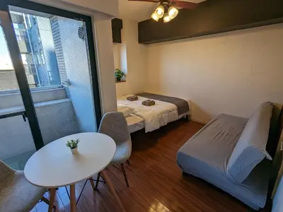 a small room with a bed and a table and a table sidx sidx at \u6b4c\u821e\u4f0e\u753a\u306e\u7269\u4ef6 \u6700\u4e0a\u968e \u6771\u65b0\u5bbf\u99c5\u5f92\u6b693\u5206\u65b0\u5bbf\u6e0b\u8c37\u539f\u5bbf\u30a8\u30ea\u30a2 in Tokyo