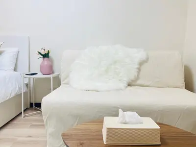 a white couch with a white fur pillow on it at Kabukicho 203-SJ0015 in Tokyo