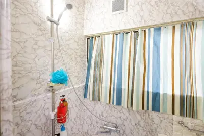 a bathroom with a shower with a fire extinguisher at Tokyo Shinjuku hotel in Tokyo