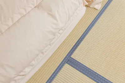 a close up of a bed with white sheets and blue stripes at Tokyo Shinjuku hotel in Tokyo