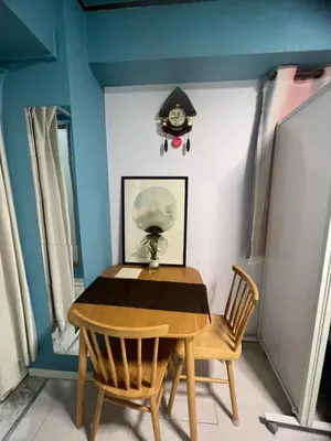 a dining room table with two chairs and a clock on the wall at \u548c\u98a8\u5ba2\u68e7 in Tokyo