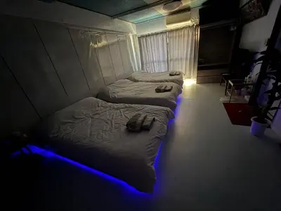three beds in a room with a blue light at \u548c\u98a8\u5ba2\u68e7 in Tokyo