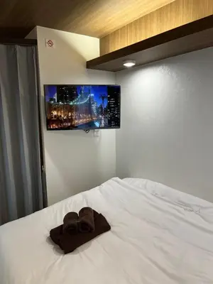 a white bed with two brown towels on it at Cozy inn Oyama in Tokyo