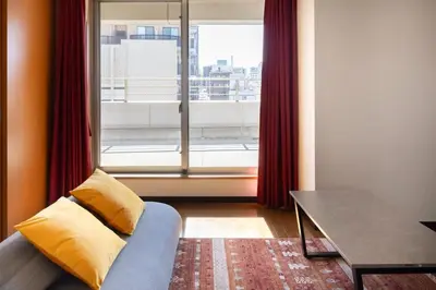 a living room with a couch and a large window at \u65e7 DeLCCS\u5c71\u5439\u795e\u697d\u5742III in Tokyo