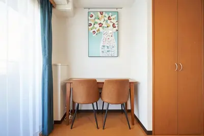 a dining room table with two chairs and a picture on the wall at \u65e7 DeLCCS\u5c71\u5439\u795e\u697d\u5742III in Tokyo