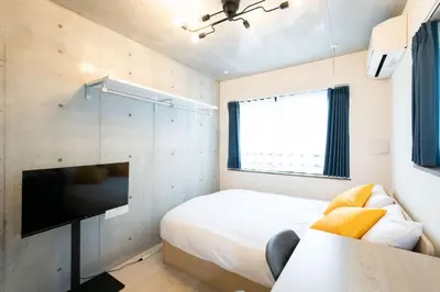 a bedroom with a bed and a flat screen tv at Ferio\u84b2\u7530II in Tokyo