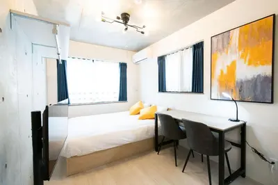 a bedroom with a bed and a table with chairs at Ferio\u84b2\u7530II in Tokyo