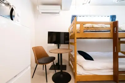 a room with bunk beds and a desk and a chair at Ferio\u84b2\u7530II in Tokyo