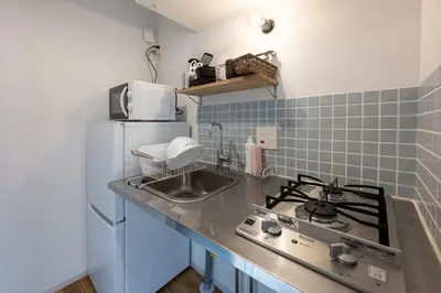 a kitchen with a stove and a sink and a refrigerator at Gran Fusion\u6c60\u888b in Tokyo