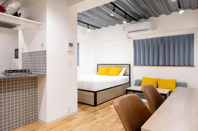 a bedroom with a bed and a table and chairs at Gran Fusion\u6c60\u888b in Tokyo