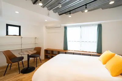 a bedroom with a bed and a table and chairs at Gran Fusion\u6c60\u888b in Tokyo