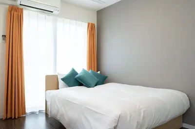 a bedroom with a white bed and a large window at Livecasa\u4e21\u56fd I in Tokyo