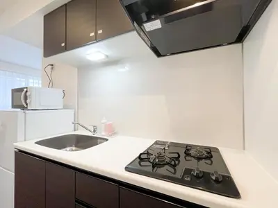 a kitchen with a black stove and a sink at Livecasa\u4e21\u56fd I in Tokyo
