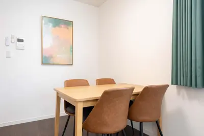 a dining room table with chairs and a painting at Livecasa\u4e21\u56fd I in Tokyo