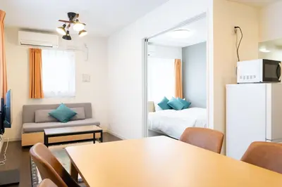 a room with a table and a bed and a mirror at Livecasa\u4e21\u56fd I in Tokyo