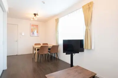 a living room with a table and a television at Livecasa\u4e21\u56fd I in Tokyo