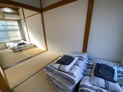 a small room with two beds and a window at Little Bird Takinogawa #1 in Tokyo