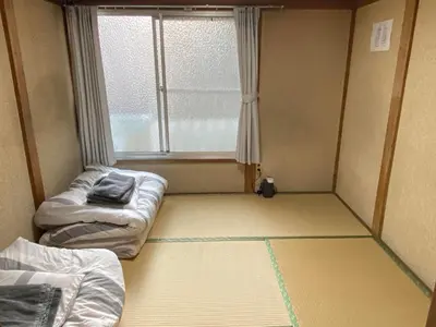 a small room with two beds and a window at Little Bird Takinogawa #1 in Tokyo