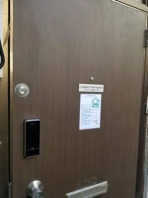 a door in a bathroom with a sign on it at Little Bird Takinogawa #1 in Tokyo