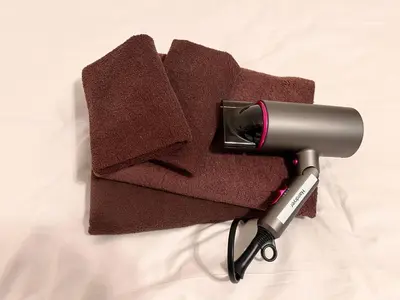 a hair dryer sitting on top of a bed at FARE Akihabara - Stylish Spacious Studio 8min from Station 201 in Tokyo