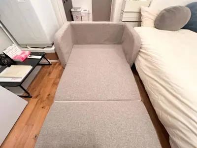 a couch sitting next to a bed in a room at FARE Akihabara - Stylish Spacious Studio 8min from Station 201 in Tokyo