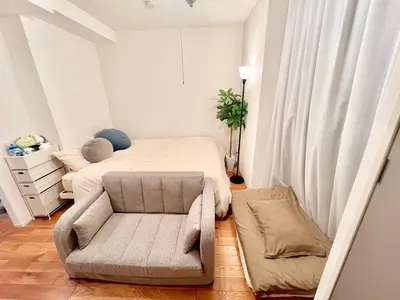 a small bedroom with a bed and a chair at FARE Akihabara - Stylish Spacious Studio 8min from Station 201 in Tokyo