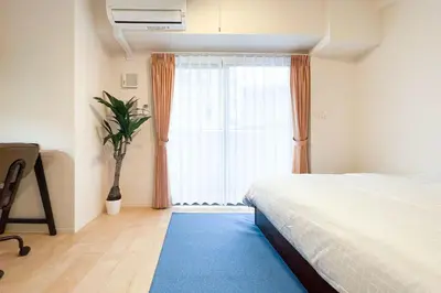 a bedroom with a bed and a large window at KiSETSU\u795e\u697d\u5742 in Tokyo