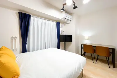 a bedroom with a white bed and a table and chairs at KiSETSU\u795e\u697d\u5742 in Tokyo