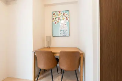 a dining room table with two chairs and a painting at KiSETSU\u795e\u697d\u5742 in Tokyo