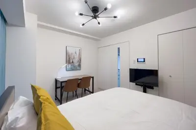 a white bedroom with a bed and a desk at \u3055\u304f\u3089\u307f\u3061\u30c6\u30e9\u30b9 in Tokyo