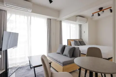 a room with a bed and a couch and a table at \u3055\u304f\u3089\u307f\u3061\u30c6\u30e9\u30b9 in Tokyo