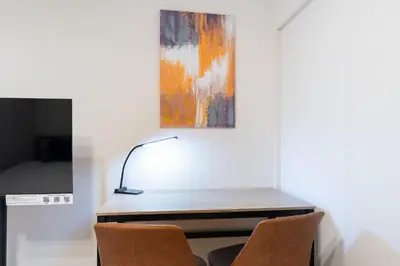 a desk with two chairs in a room with a painting at \u3055\u304f\u3089\u307f\u3061\u30c6\u30e9\u30b9 in Tokyo
