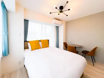 a bedroom with a large white bed with yellow pillows at \u3055\u304f\u3089\u307f\u3061\u30c6\u30e9\u30b9 in Tokyo