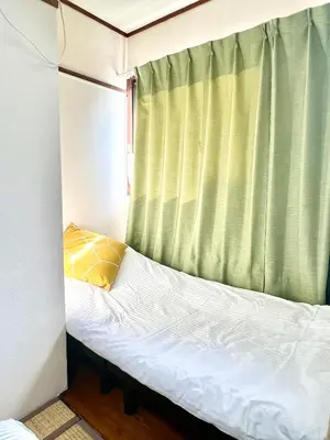 a small bed in a small room with a window at Hotel KinRin in Tokyo