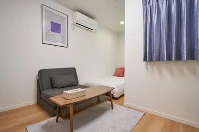 a room with a chair and a table and a bed at KiSETSU\u5de3\u9d28 in Tokyo