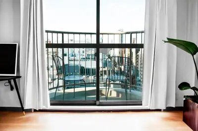 a room with a balcony with two chairs and a window at #9 3mins to station 1stop to Shinjuku Stylish apartment with plenty of sunlight in Tokyo