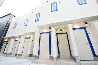a white building with blue doors on it at \u30bb\u30f3\u30c8\u30ec\u30a4 \u62bc\u4e0a\u30ce\u30fc\u30b9103 in Tokyo