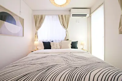 a bedroom with a large bed and a window at \u897f\u5de3\u9d28HOUSE in Tokyo